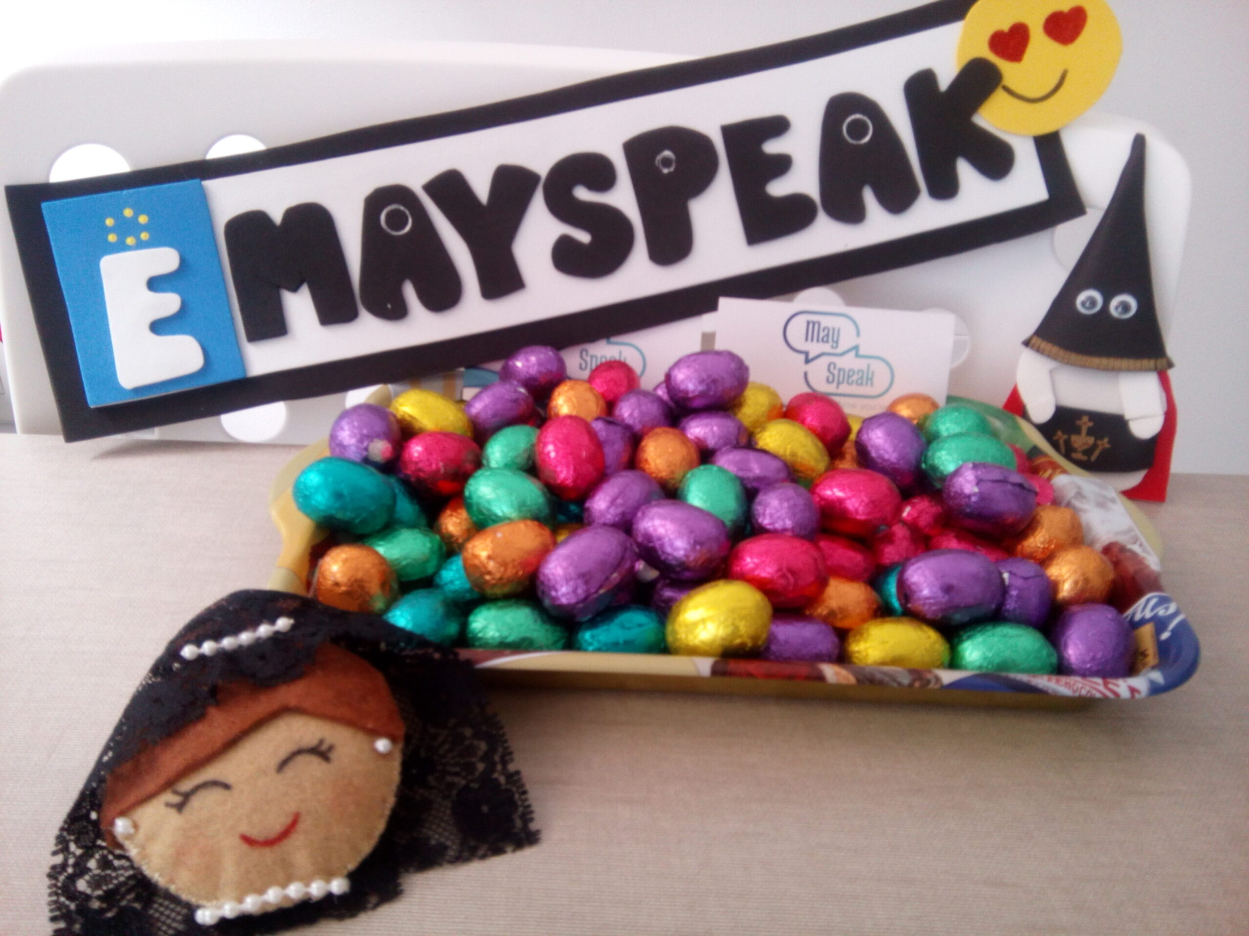 Niños y jóvenes realizando manualidades y juegos en inglés durante la Semana Santa en la academia Mayspeak, decorada con motivos primaverales.